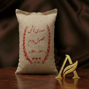 بسته برنج صدری هاشمی کشت دوم با طراحی گونی کنفی، در کنار مواد غذایی تازه شامل گوشت، برنج خام، ادویه، فلفل قرمز، سیر و قارچ بر زمینه صورتی